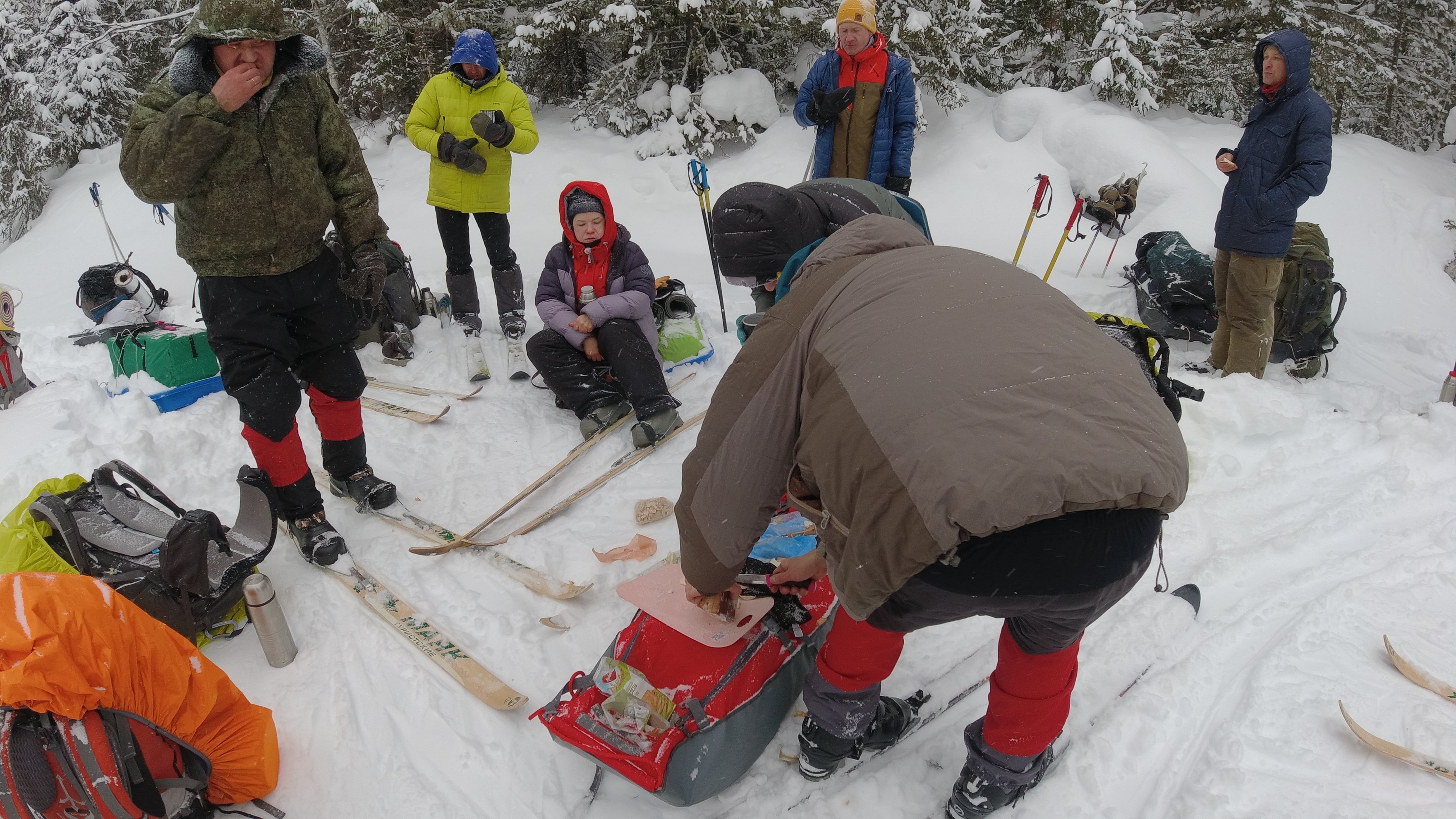 person preparing food from a red sled in the snow