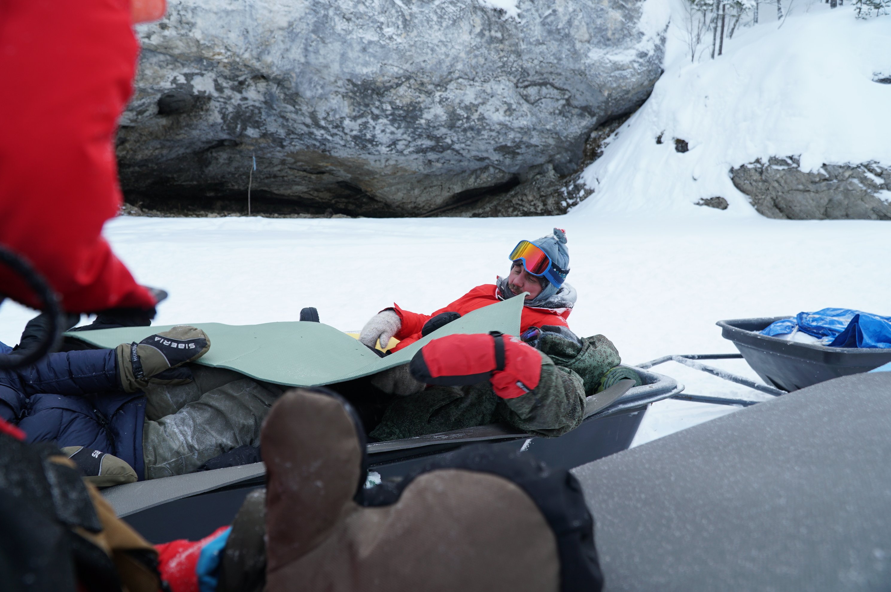 person wearing gloves and goggles handling equipment on a sledge