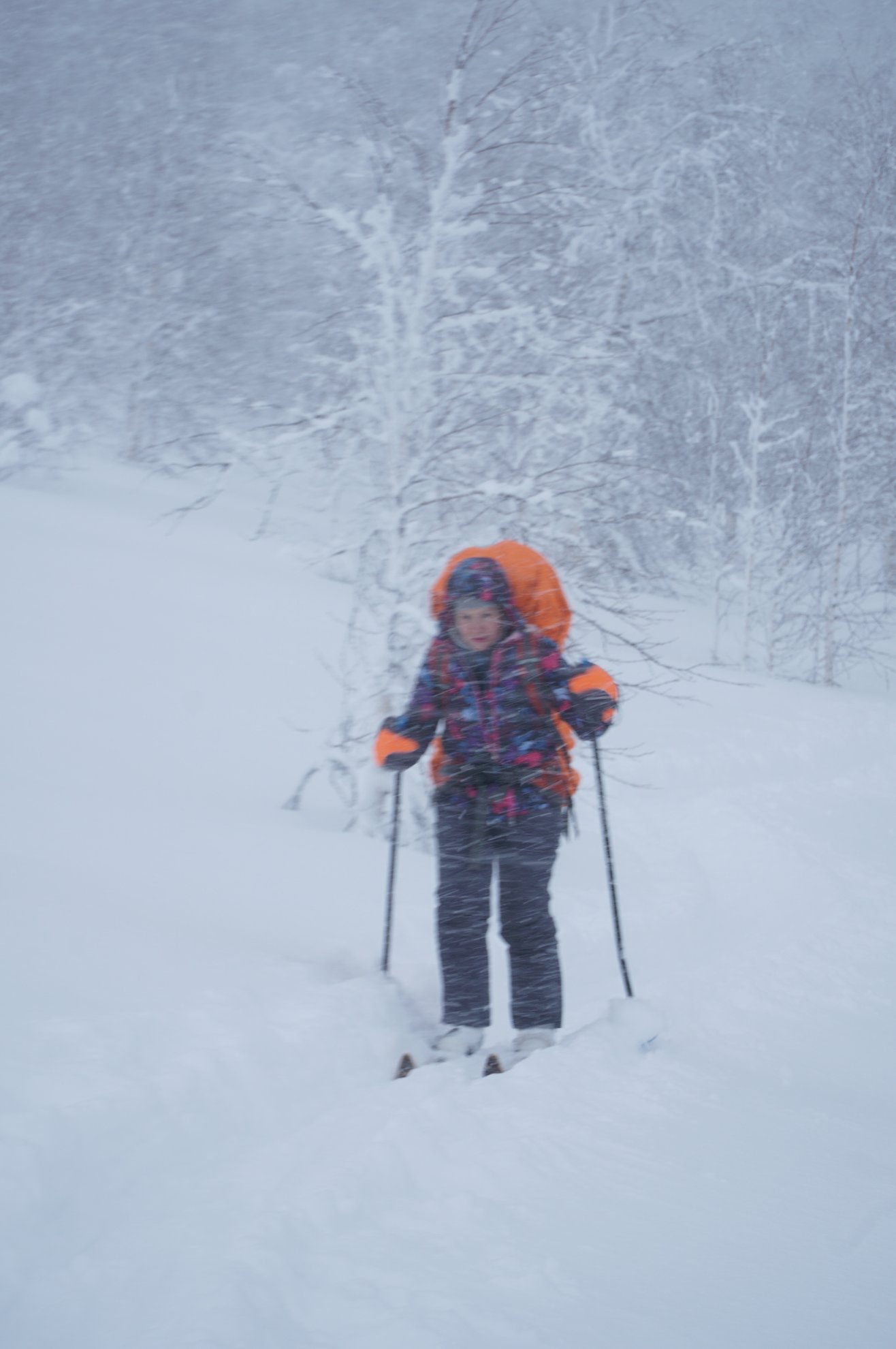 person skiing through snow with a backpack and poles