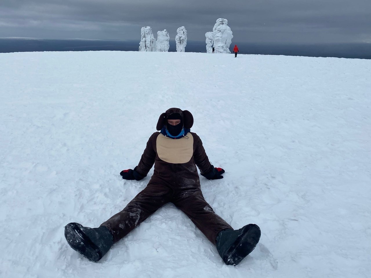 Person sitting in snow with stone pillars in background