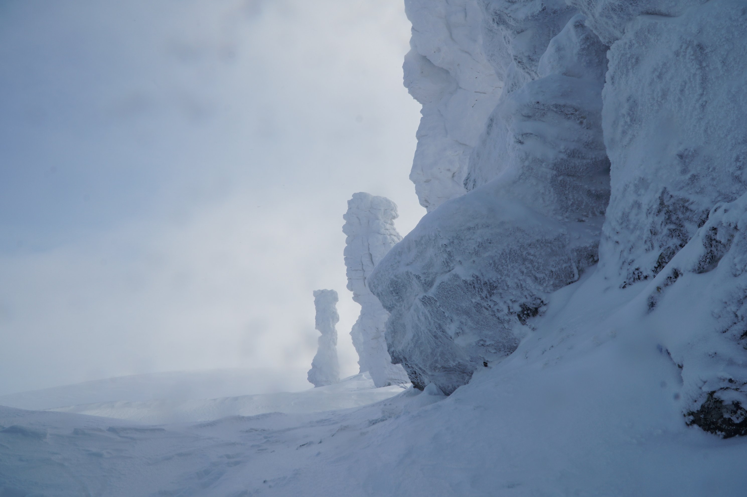 grande plano de pilares de pedra cobertos de neve sob geada