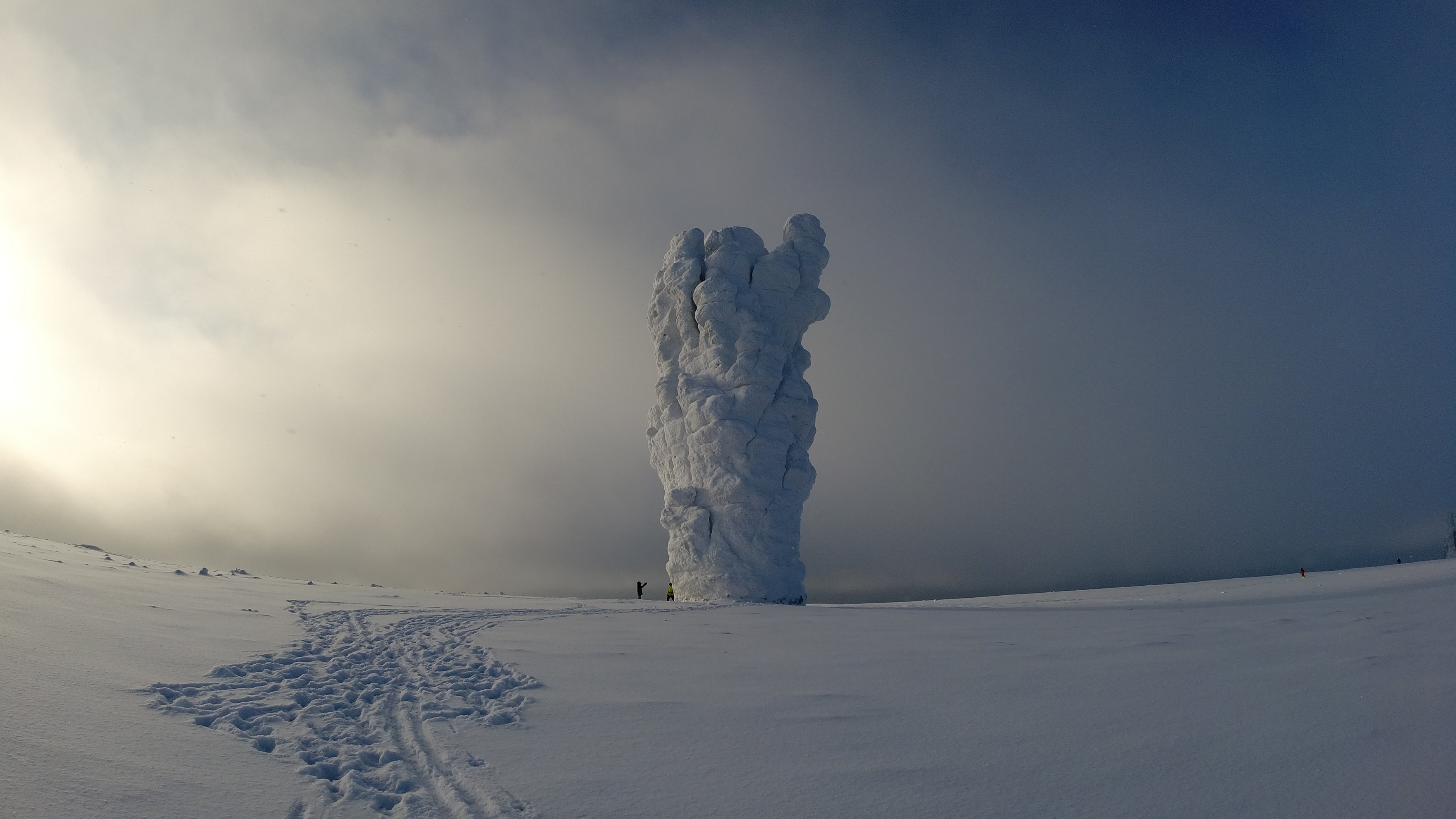pilar de pedra coberto de neve num campo branco