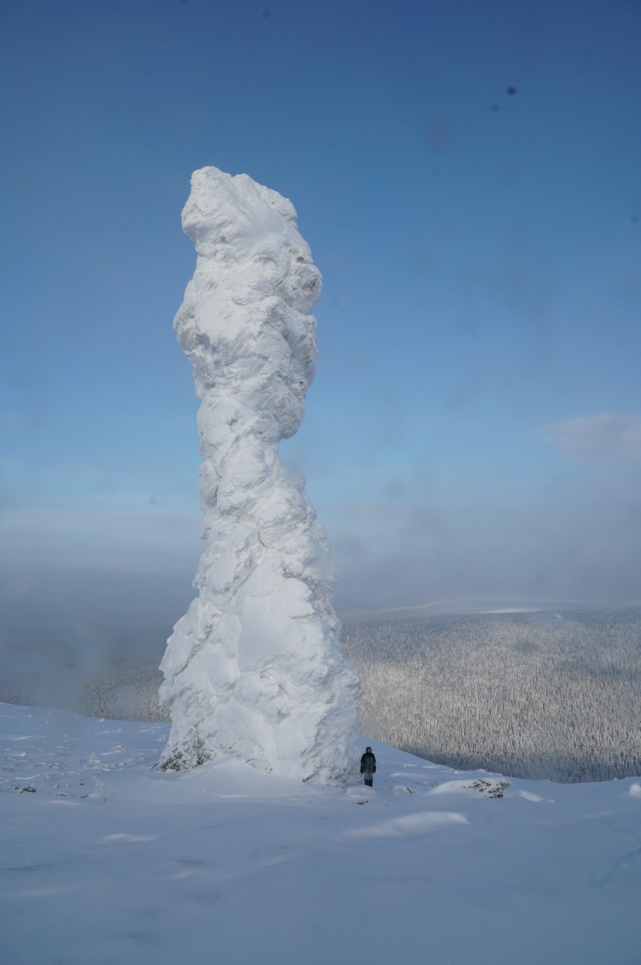 Pilar de pedra coberto de neve contra um céu azul