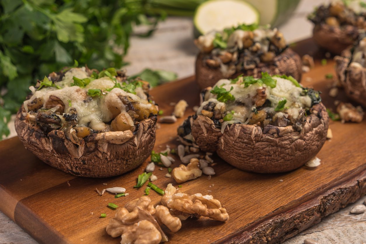 close up of mushrooms on a wooden board with walnuts