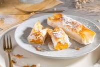 Three pastries on a plate with one cut into pieces