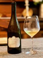 Chilled bottle and glass of white wine on a table