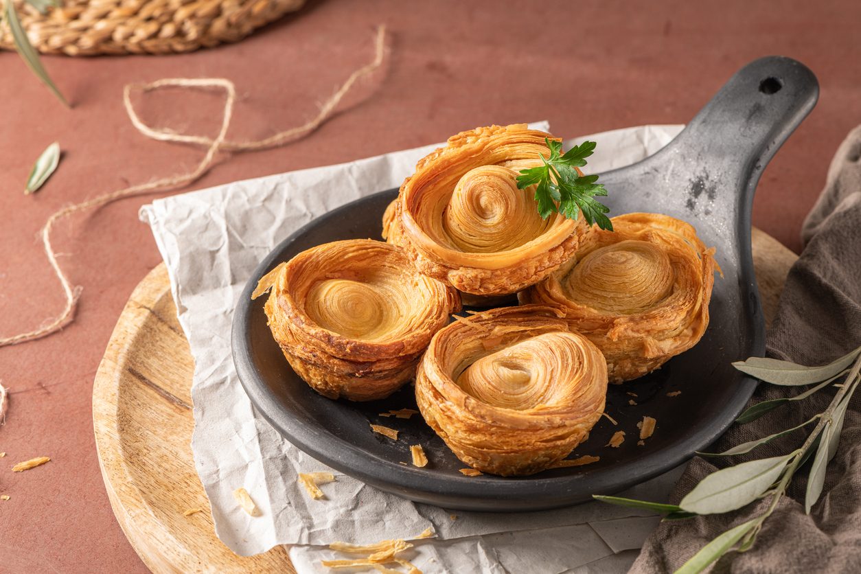 four pastries on a black plate with parsley garnish