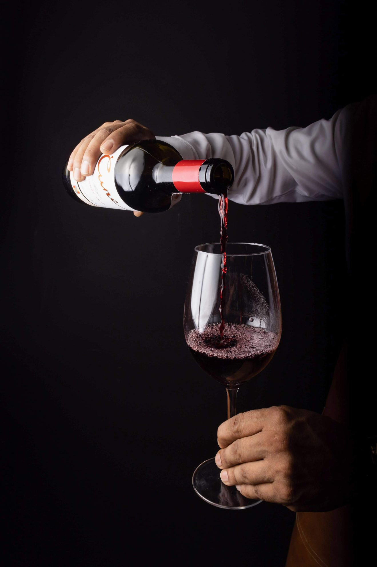 wine pouring from bottle into glass