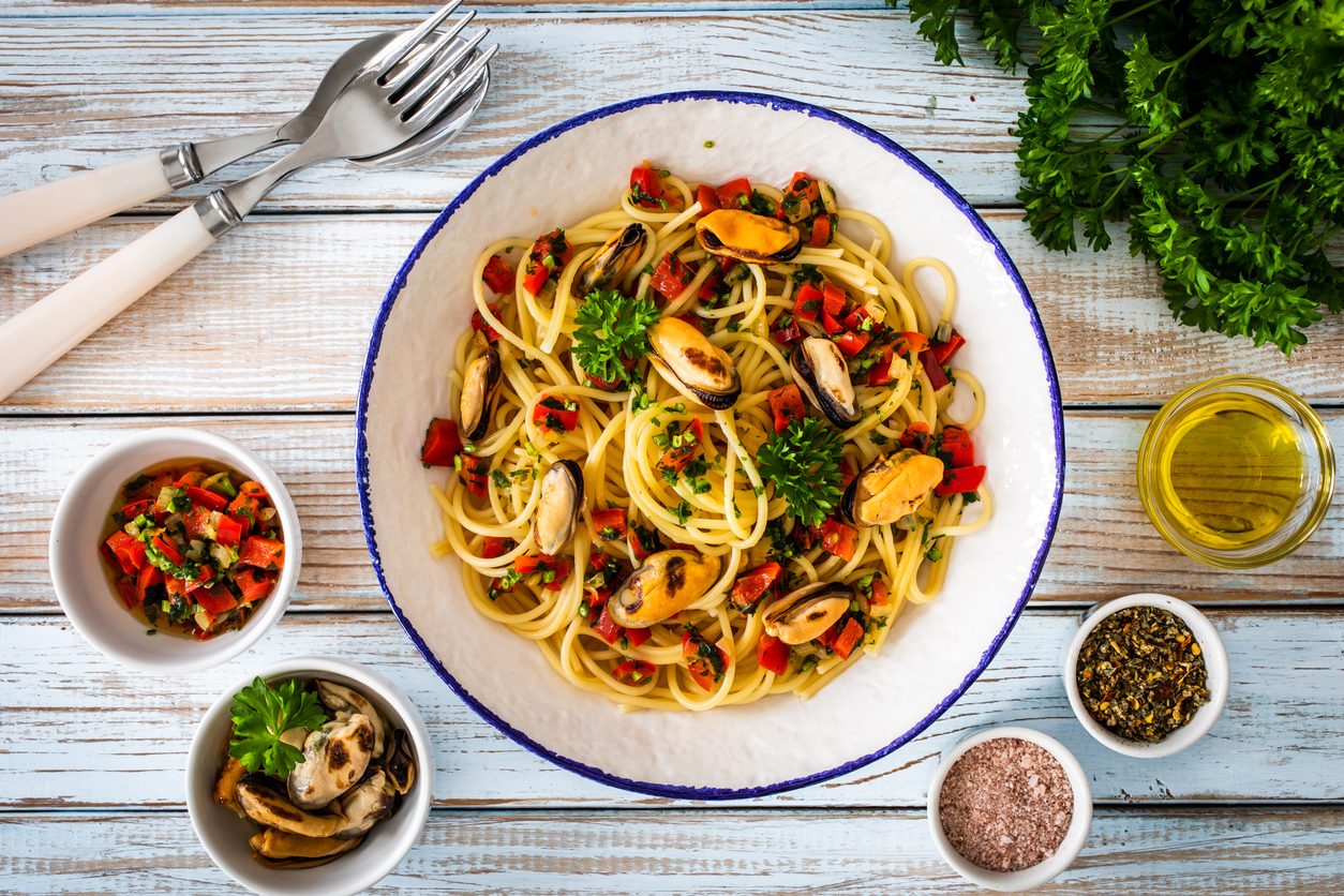 Top down view of pasta bowl with side condiments