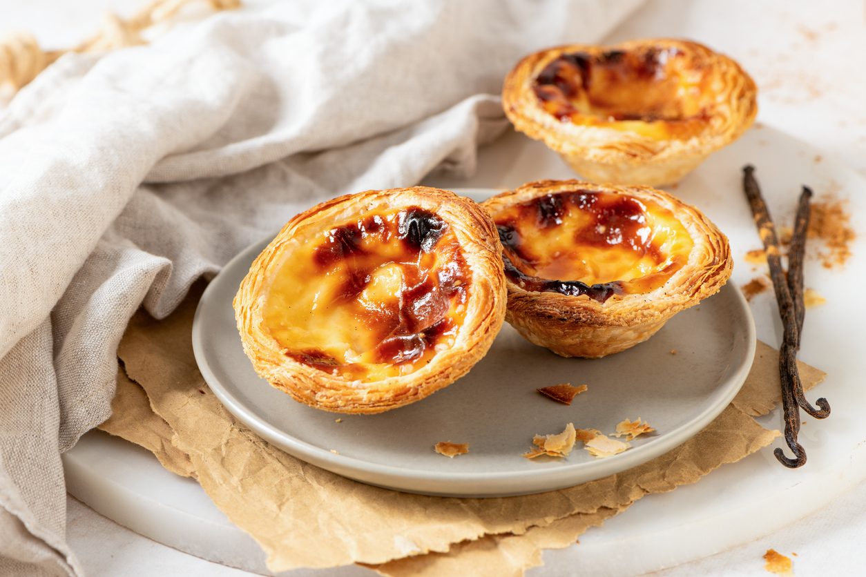 Three tarts on a plate with vanilla beans