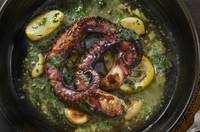 Top-down view of octopus tentacles in garlic butter and lemon