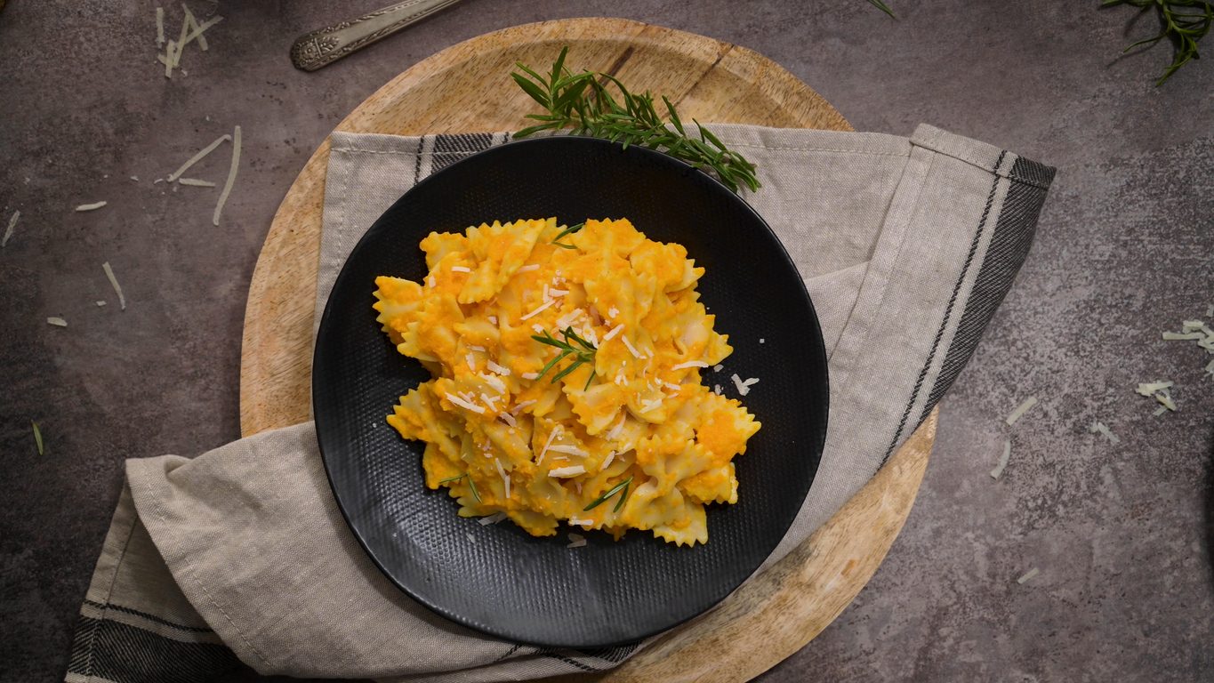 Top-down view of pasta in a black bowl on wood