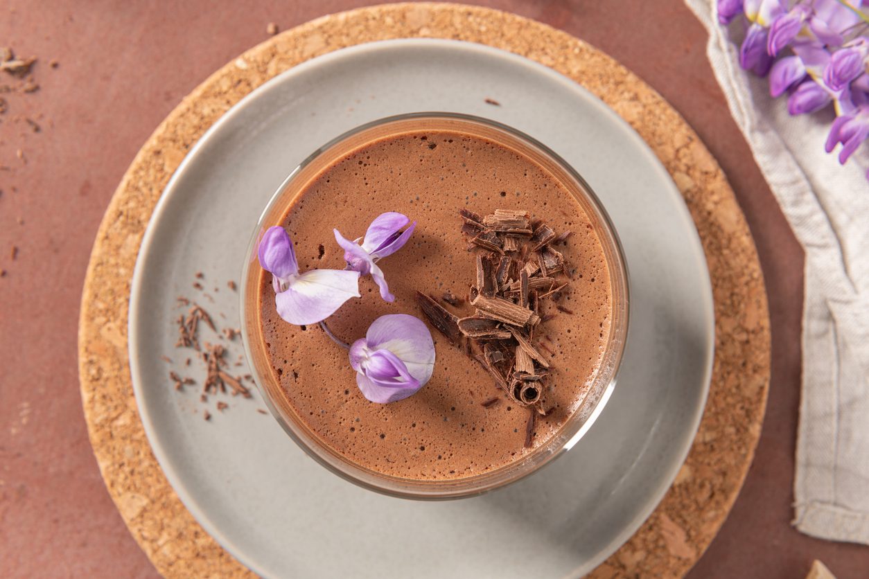 top view of mousse in glass with chocolate shavings and flowers