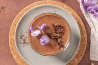top view of mousse in glass with chocolate shavings and flowers