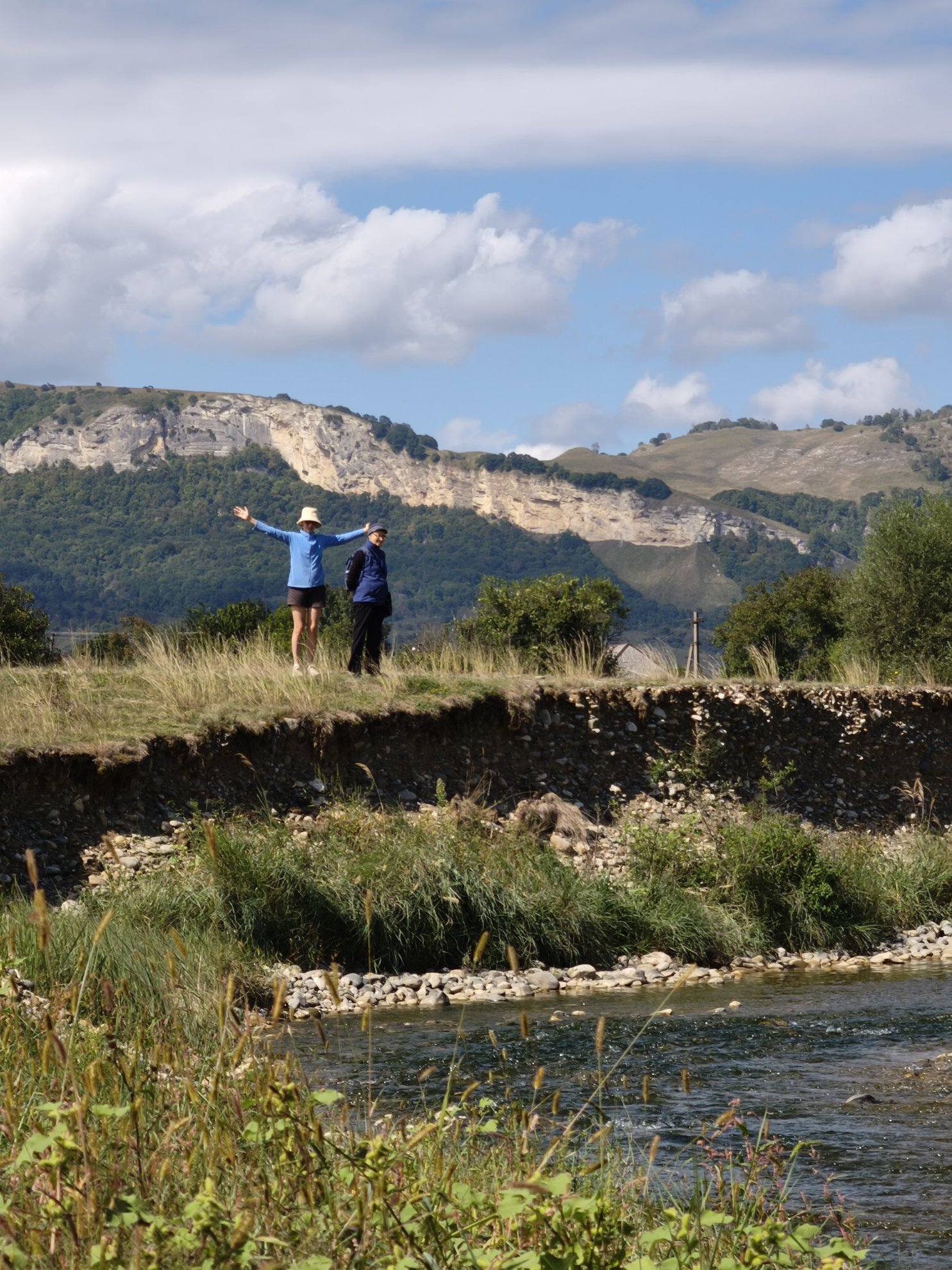 riverbank overlook with cliffs and mountains in background