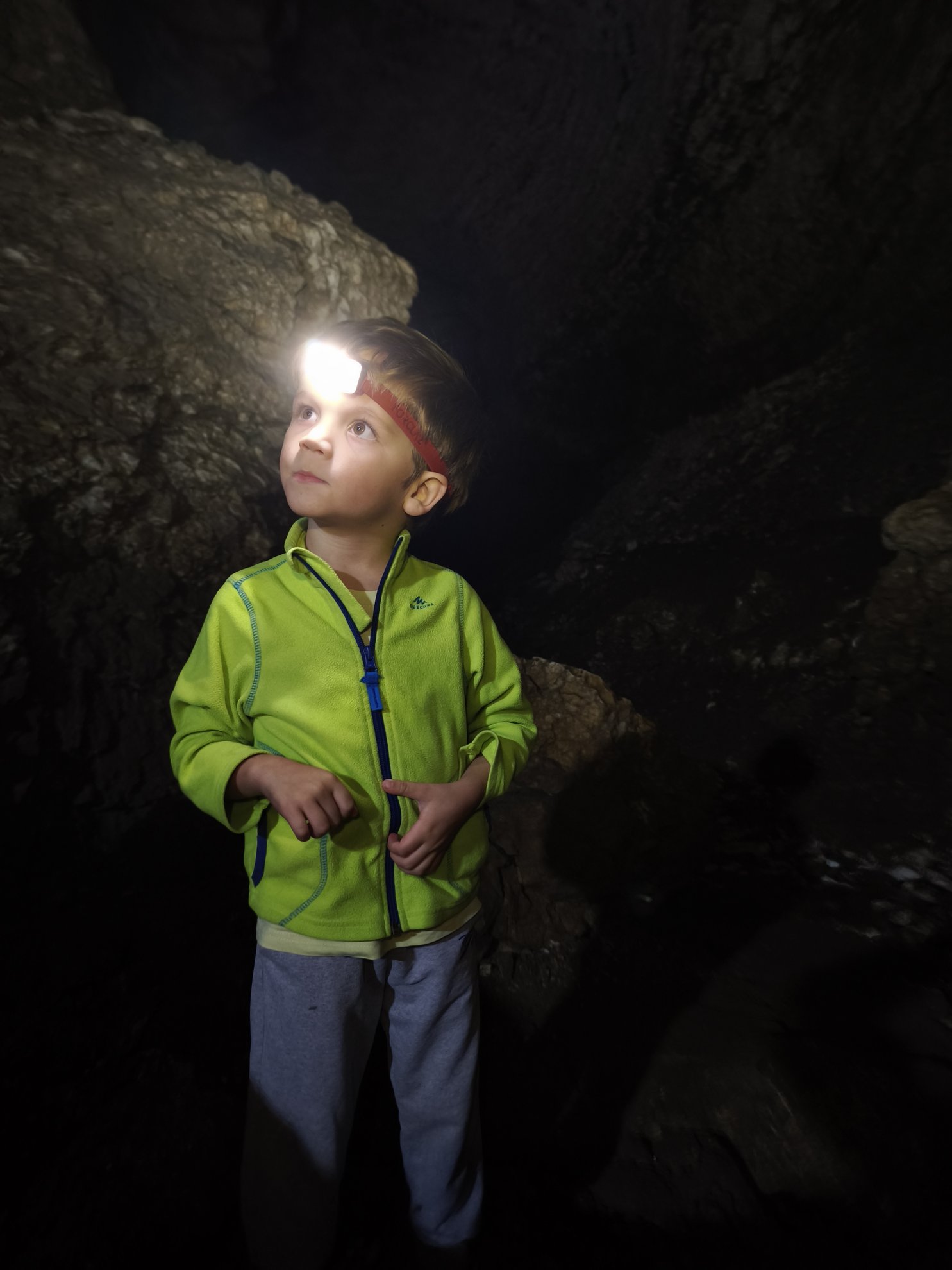 Parede rochosa interior iluminada por uma lanterna de cabeça