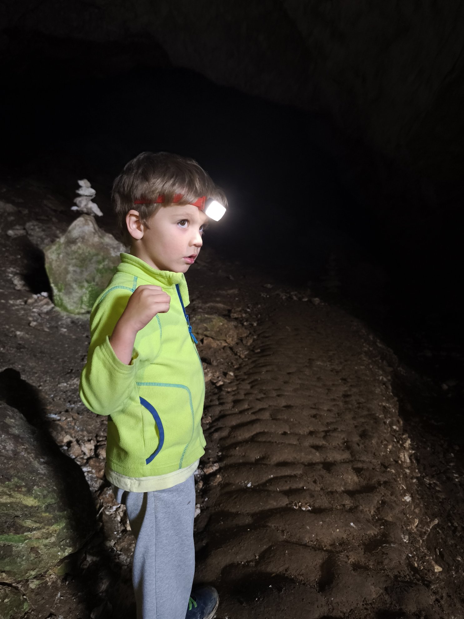 vista interior de um caminho numa gruta com uma lanterna de cabeça