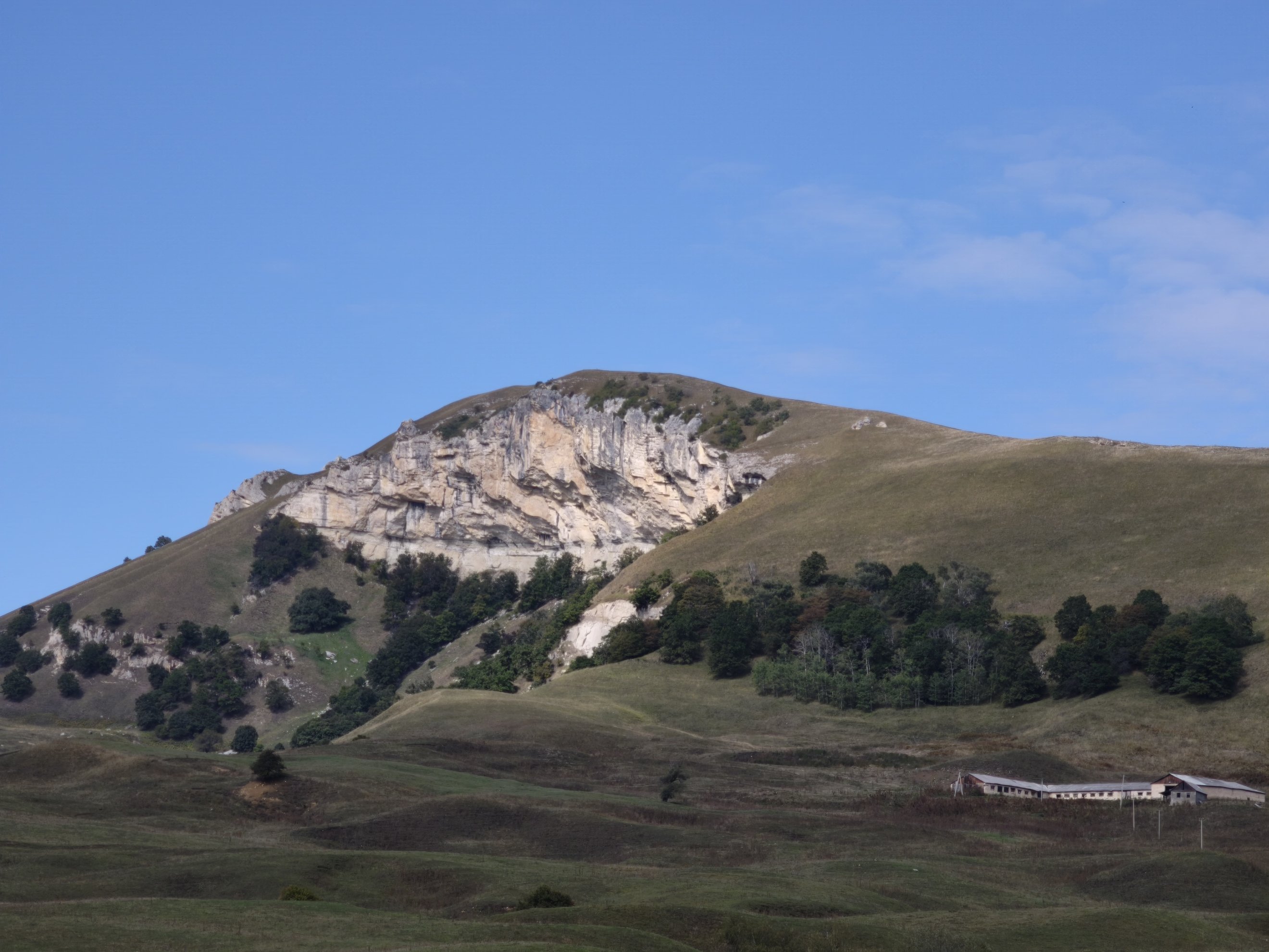 wide shot of the cliff face and surrounding slopes