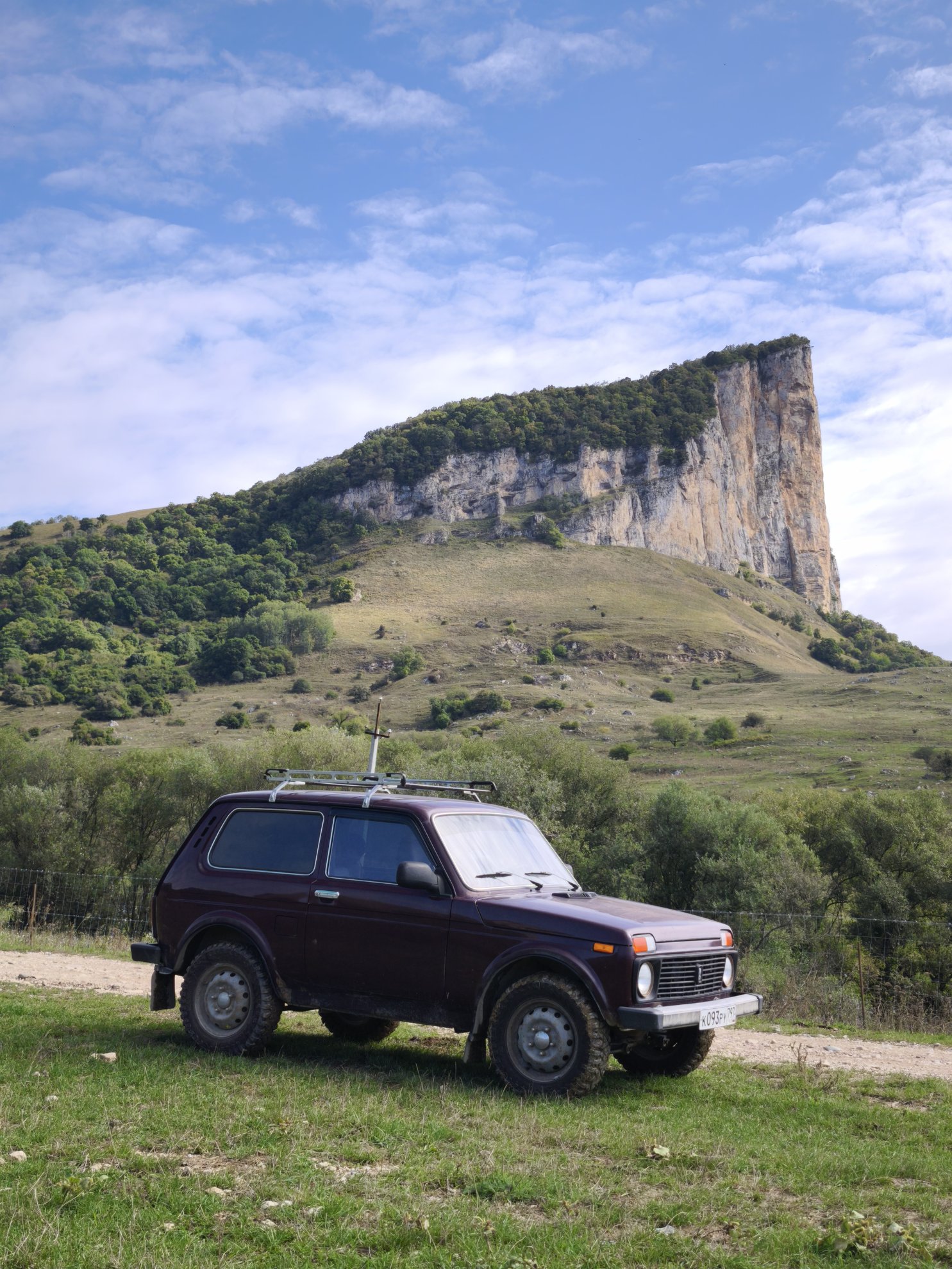 Off-road vehicle parked before the cliff face