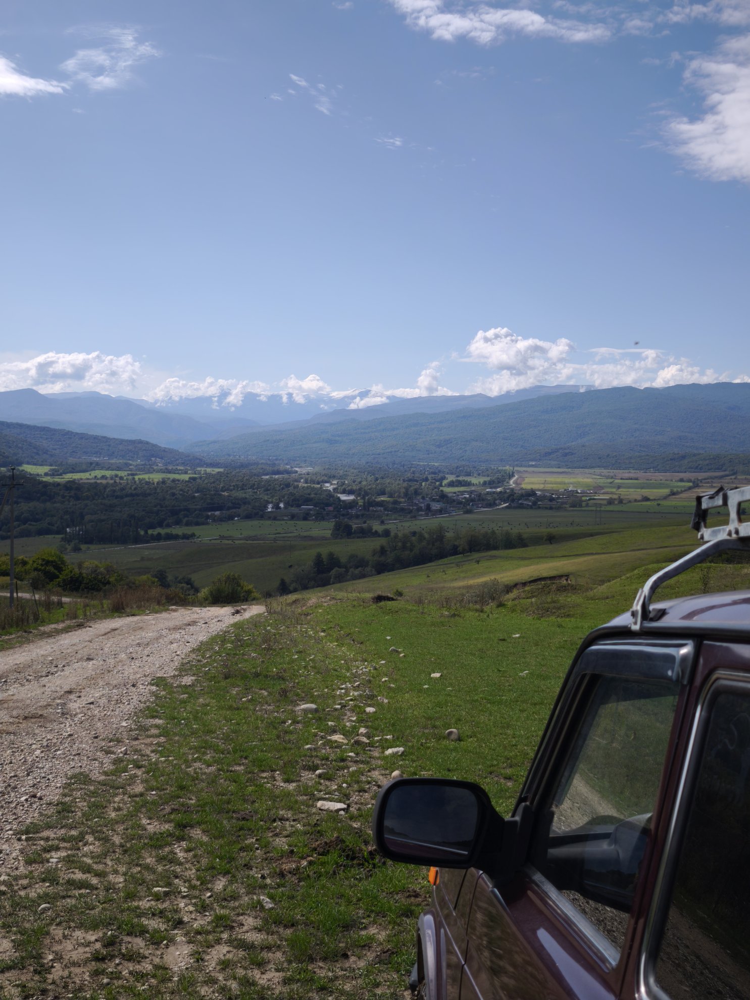 Dirt road and off-road vehicle overlooking the valley