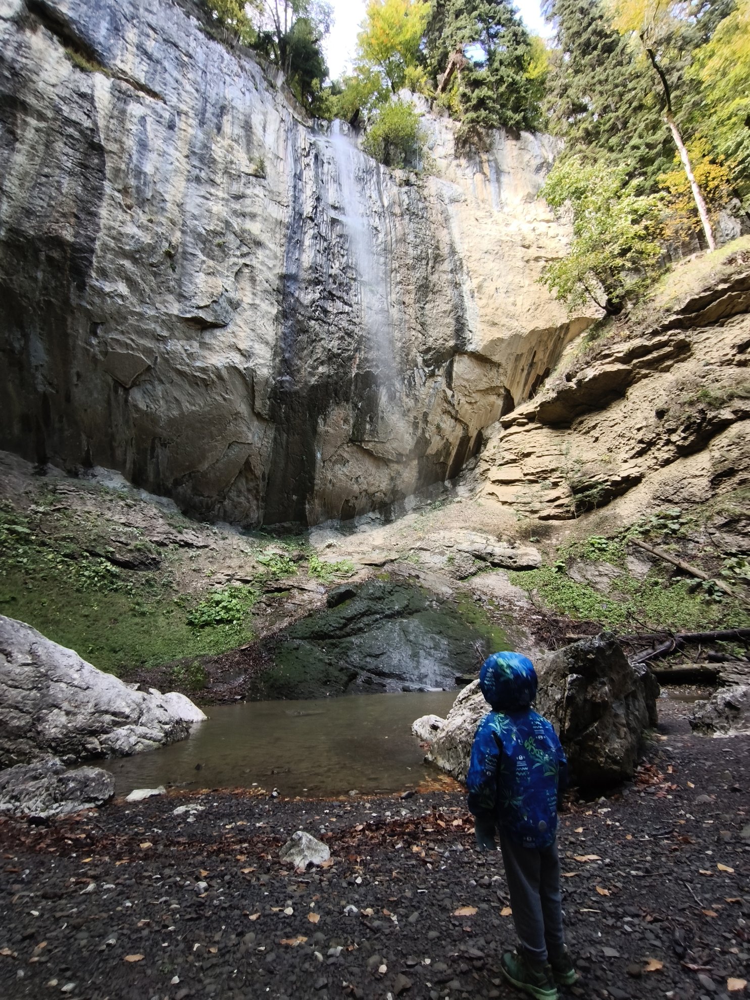 waterfall falling from cliff into a pool