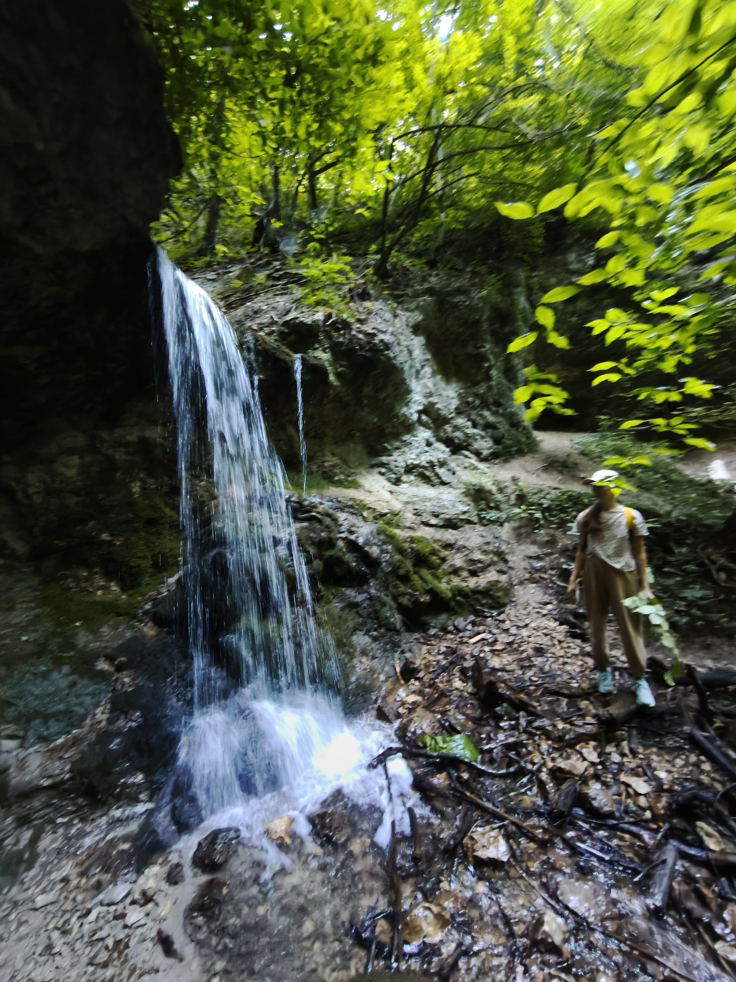 cascata a correr sobre rochas para uma piscina natural