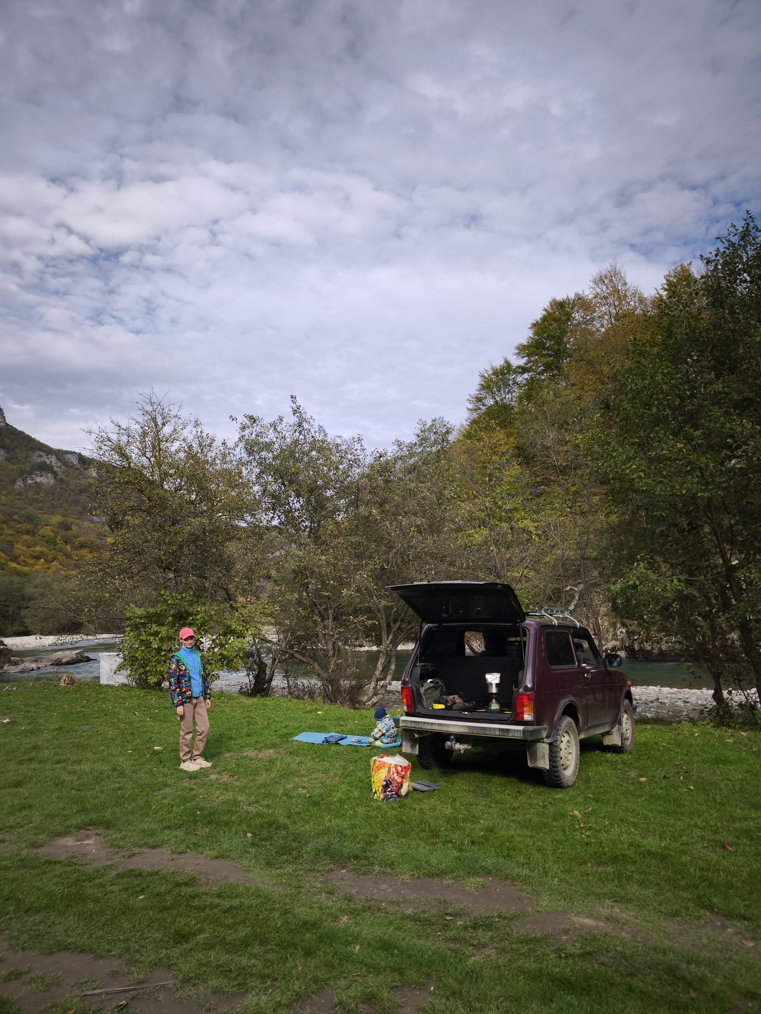 car parked on grass beside the river