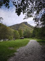 gravel road leading toward a mountain and car